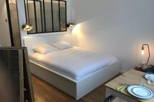 a small bedroom with a bed and a table at Le Joyau de Jouhaux appartement G - Lyon Garibaldi in Lyon