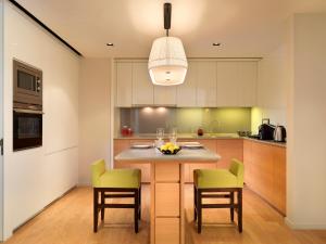 a kitchen with a island with two chairs and a table at Lanson Place Bukit Ceylon in Kuala Lumpur