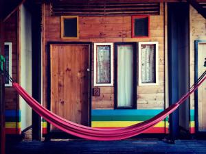 a hammock in front of a building with a door at Cafe del sunshine in Ko Chang