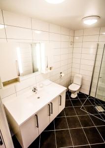 a bathroom with a white sink and a toilet at Utsira Overnatting - Bølgen in Utsira