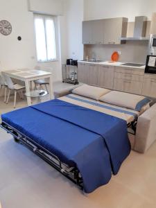 une chambre avec un grand lit bleu dans une cuisine dans l'établissement Suite Rent Milan 2, à Milan