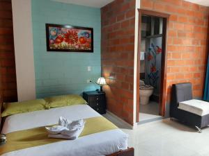 a bedroom with a bed and a television at Hostal Balcon del Cielo in Baños