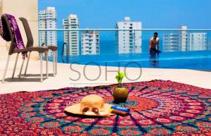 una mesa con un sombrero en una alfombra en un balcón en Apartamentos Velas al Mar - Cerca al Mar by SOHO, en Santa Marta