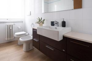 een badkamer met een witte wastafel en een toilet bij Cute & Cozy rooms train station in Bergamo