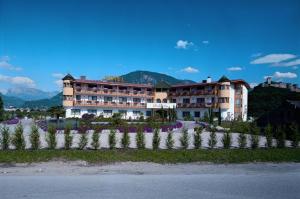 un grand bâtiment avec un jardin en face dans l'établissement Gardenhotel Premstaller, à Bolzano