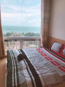 a bed in a room with a large window at Sơn Thịnh - Seahouse in Vung Tau
