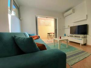 a living room with a couch and a tv and a table at Sail Ocean View Apartments in Sarandë