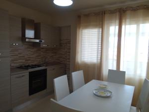 a kitchen with a white table and white chairs at Residence Agave Lampedusa in Lampedusa