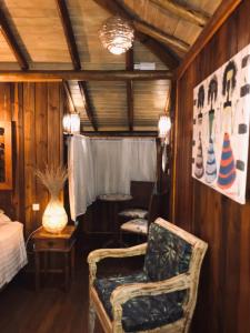 a living room with a chair and a table at Pousada de Charme Emirados in Ilhabela