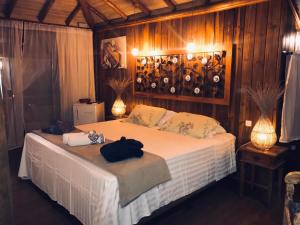 um quarto com uma cama num quarto com paredes de madeira em Pousada de Charme Emirados em Ilhabela