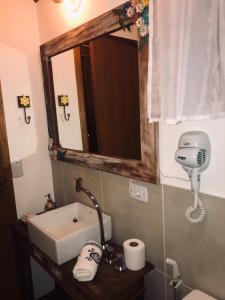 y baño con lavabo y espejo. en Pousada de Charme Emirados, en Ilhabela