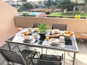 - une table avec de la nourriture sur le balcon dans l'établissement Appartement 2 pieces, renove, 2 piscines+tennis, mer, climatisation, à Antibes