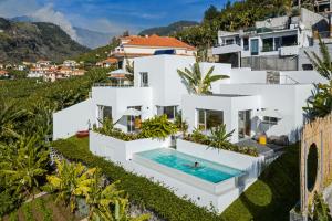 an aerial view of a white house with a swimming pool at Casas da Vargem shared swimming pool by An Island Apart in Ponta do Sol