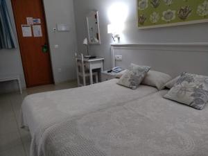 a bedroom with a large bed with two pillows at Hotel Goya in Seville