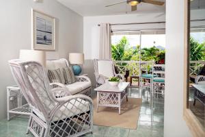 ein Wohnzimmer mit Stühlen und einem Tisch in der Unterkunft Harmony Marina Suites in Rodney Bay Village