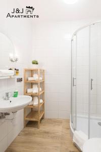 W łazience znajduje się umywalka i prysznic. w obiekcie J&J Apartments, Szeroka 25 Apartament 7 w Toruniu