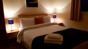 a bedroom with a large bed with towels on it at The Auld Triangle in Loughrea