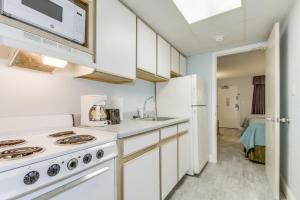マートルビーチにあるHosteeva Oceanfront Boardwalk Beach Resort with Balconyのキッチン(白いキャビネット、コンロ付)