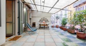 une terrasse avec une table, des chaises et des plantes en pot dans l'établissement ALTIDO Apt for 6 with Big Terrace in Milan Centro Storico, à Milan