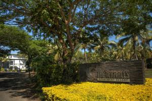 a sign in front of a park with trees and yellow flowers at The Terraces Apartments Denarau in Denarau