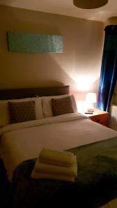 - une chambre avec un lit blanc et 2 serviettes dans l'établissement The Auld Triangle, à Loughrea
