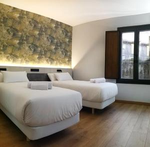 a room with two beds and a painting on the wall at Hotel NERU con Encanto in León