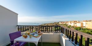 d'un balcon avec une table et une vue sur l'océan. dans l'établissement Hôtel Bellevue Cap d'Agde, au Cap d'Agde