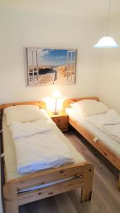 two beds in a room with a picture of a beach at Vier Jahreszeiten Haus 1 Whg 06 in Großenbrode