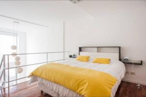 um quarto com uma cama grande com lençóis amarelos em Luminosos Loft En Recoleta 2 Cuadras Del Subte em Buenos Aires