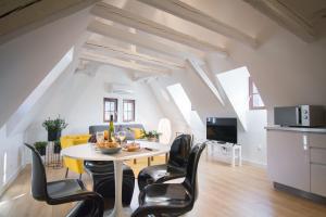 a dining room and living room with a table and chairs at Les apparts du marché in Obernai