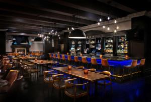 un restaurant avec des tables et des chaises ainsi qu'un bar dans l'établissement Hyatt Regency Calgary, à Calgary