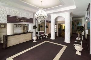 een hotellobby met een kroonluchter en een salon bij Flowers Hotel in Chişinău