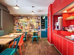 un restaurante con mesas, sillas y paredes rojas en hotelF1 Compiègne, en Venette