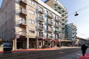 a man walking down a street in front of a building at Host Wise - Trendy Bright Flats with Jacuzzi - 5 min Beach in Matosinhos
