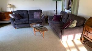 a living room with two couches and a coffee table at Hayloft Cottage - Dog Friendly With Private Garden in Sidmouth