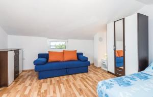 a living room with a blue couch and a bed at Apartment Miro in Prvić Šepurine
