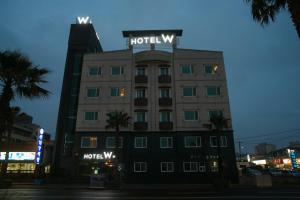 a hotel building with a sign on top of it at Hotel W Topdong in Jeju