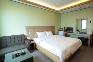 Habitación de hotel con cama y sofá en Hotel W Topdong en Jeju