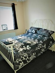 a bedroom with a bed with a black and white comforter at Home from Home, Great Community!! in London