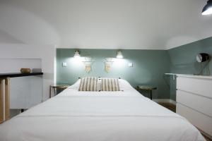 ein großes weißes Bett in einem Zimmer mit grünen Wänden in der Unterkunft Le duplex d'André - Un écrin cosy et design pour 2 in Lyon