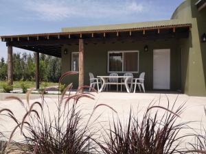 Casa con patio con mesa y sillas en Hostel de campo La Providencia en Lobos