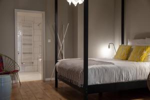 a bedroom with a large bed with yellow pillows at The Suite Hotel Fabric in Frankfurt