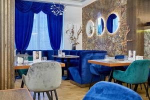 a dining room with blue chairs and tables at Kayus in Buşteni