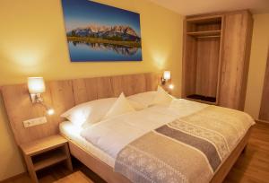 um quarto com uma cama com uma fotografia na parede em Ferienwohnung Hinterkaiser em Sankt Johann in Tirol