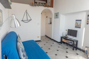 ein Wohnzimmer mit einem blauen Sofa und einem TV in der Unterkunft Cosy Apartment by PortofinoVip in Rapallo