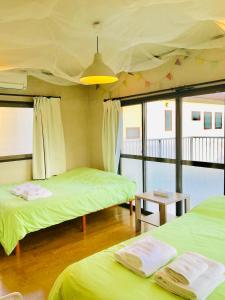 広島市にあるwest crab baseのベッド2台と天井が備わる客室です。