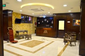 een lobby met een kamer met meubilair en een televisie bij Saint John Hotel in Madaba