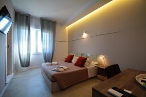 - une chambre avec un lit, un bureau et une télévision dans l'établissement Graffiti, à Matera