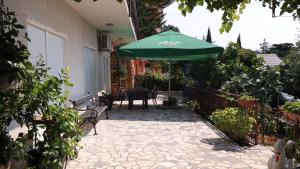 une terrasse avec un parasol vert et une table dans l'établissement Apartman Ana, à Novi Vinodolski