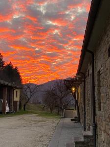 una puesta de sol sobre un edificio con un cielo rojo en Agriturismo Popolano Di Sotto, en Marradi